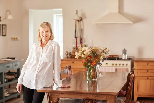 Woman at home leaning on wooden table — Stock Photo, Image