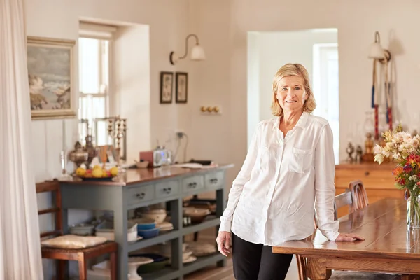 Woman at home leaning on wooden table — Stock Photo, Image