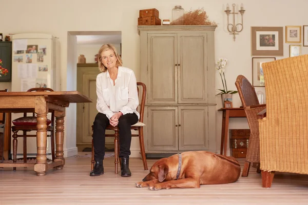 Mujer sentada en silla de madera con perro — Foto de Stock