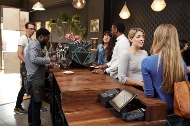 Baristas kafenin tezgahının arkasında çalışıyor