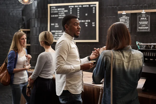 Mixed race friends talking at counter — Stock Photo, Image