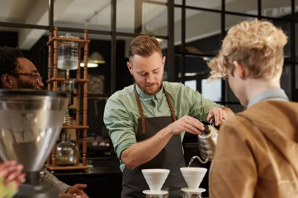 Barista pouring coffee through filter — Stock Photo, Image