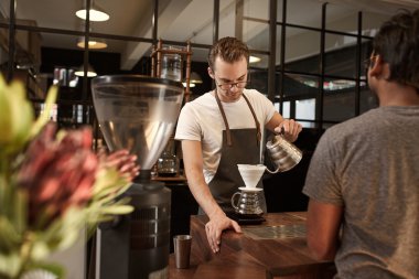 Barista modern kafede kahve döküyor