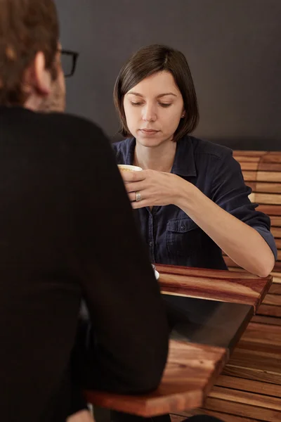 Kobieta trzyma kawę i patrząc w dół — Zdjęcie stockowe