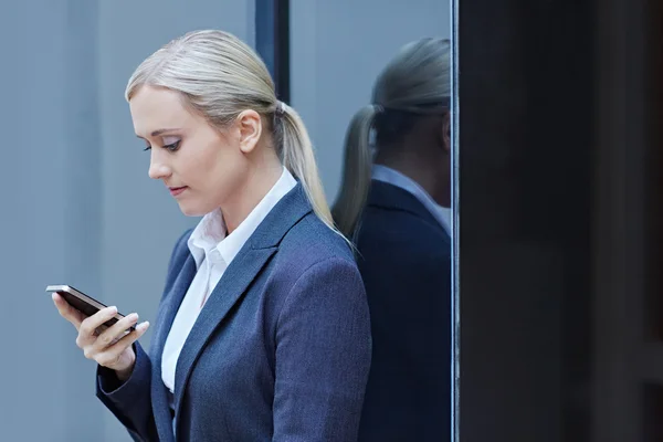 Donna d'affari digitando sms sul telefono — Foto Stock