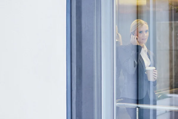 Donna d'affari che parla al telefono in ascensore — Foto Stock
