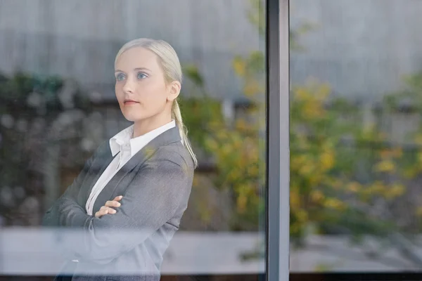 Geschäftsfrau blickt durch Fenster — Stockfoto