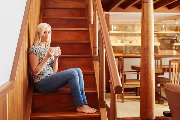 Woman sitting on stairs and drinking coffee — Stock Photo, Image