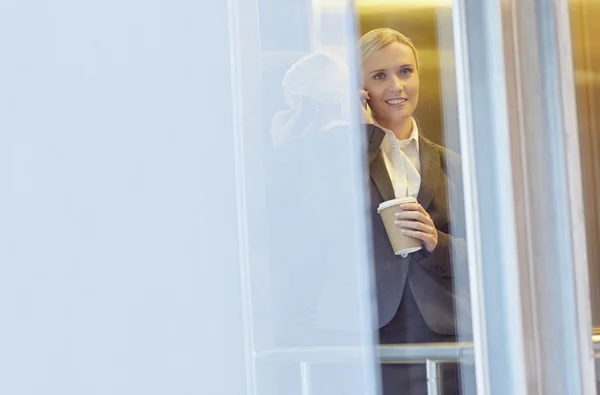 Empresária falando ao telefone no elevador — Fotografia de Stock