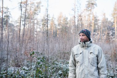 don ile ormanda sıcak giyinmiş adam