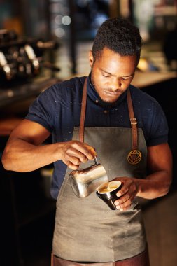 barista cappuccino içinde köpüklü süt dökme