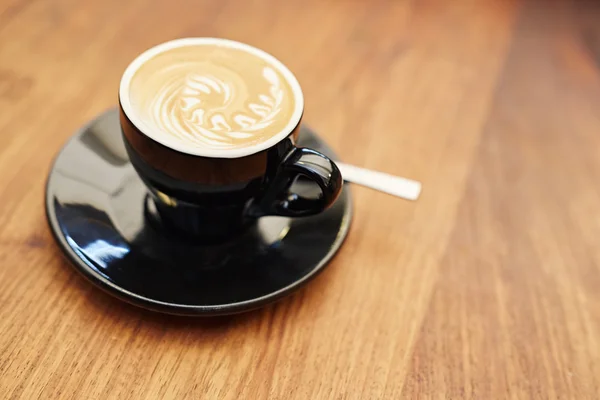 Cappuccino in tazza di ceramica nera — Foto Stock