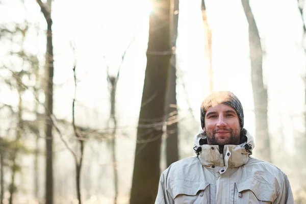 Homem com sorriso em pé na floresta de inverno — Fotografia de Stock