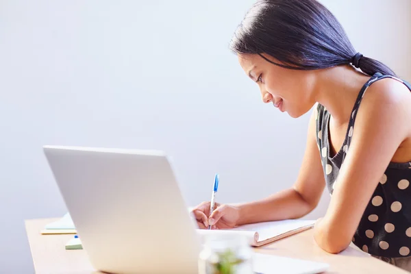 Wanita menulis sambil duduk di kantor — Stok Foto