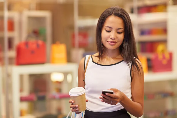Vrouw in winkelcentrum-tekstberichten versturen — Stockfoto