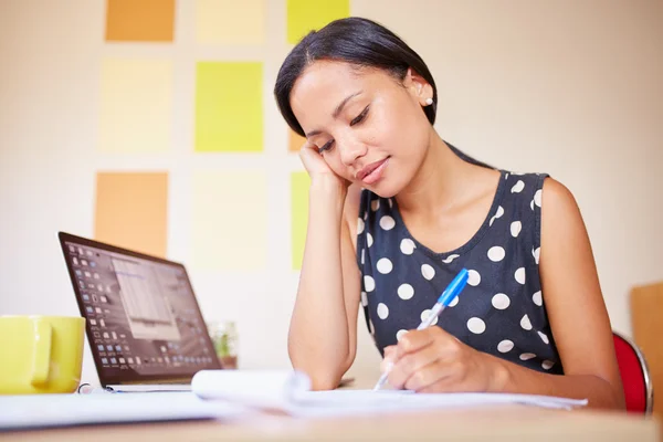 Mulher escrevendo enquanto sentado no escritório — Fotografia de Stock