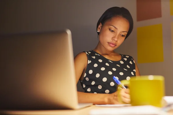 Woman writing while sitting in office — Stock Photo, Image