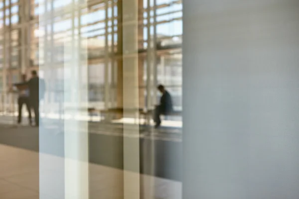 Real businesspeople in motion through glass — Stock Photo, Image