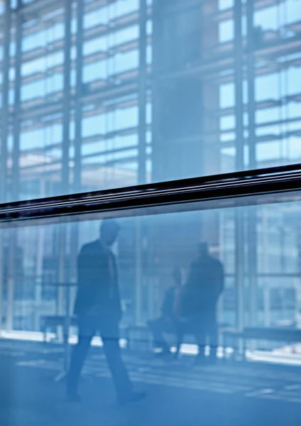 Real businesspeople in motion through glass — Stock Photo, Image