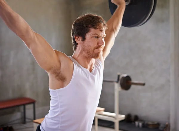 Man lifting heavy weights in gym — Stock Photo, Image