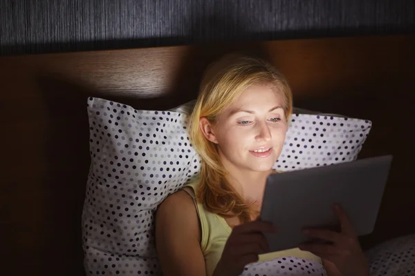 침대에서 태블릿에 노력 하는 여자 — 스톡 사진