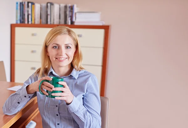 Affärskvinna som ler mot kameran i hennes kontor — Stockfoto
