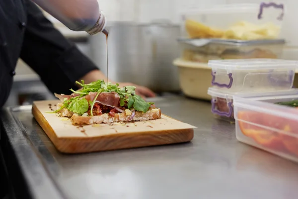 Chef rociando vinagre balsámico en sándwich —  Fotos de Stock