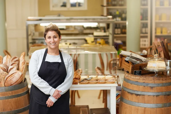 Deli werknemer staande voor gebak — Stockfoto