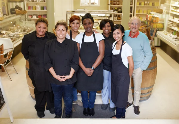 Trabajadores de delicatessen de pie juntos en tienda —  Fotos de Stock