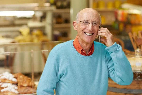 Propietario de delicatessen hablando por teléfono —  Fotos de Stock