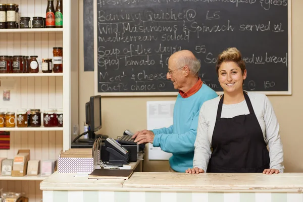 Business owners standing behind counter — Stock Photo, Image