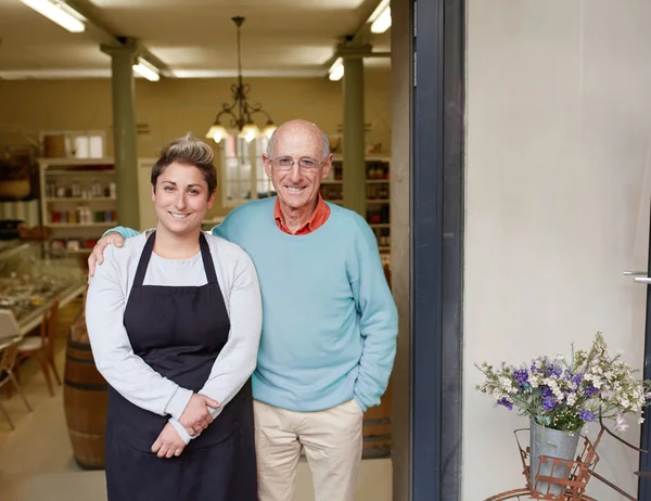 Владелец и дочь, стоящие в магазине — стоковое фото