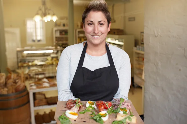 Deli-werknemer bezorgt snack plaat — Stockfoto