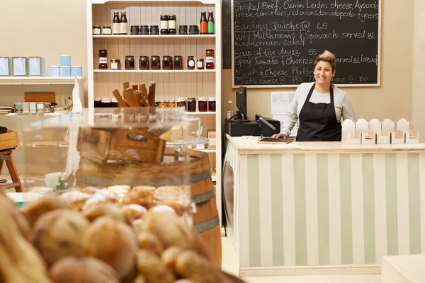 Deli trabajador de pie detrás del mostrador — Foto de Stock