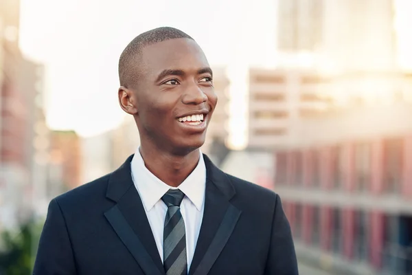 Бизнесмен смотрит вдаль с оптимистической улыбкой — стоковое фото