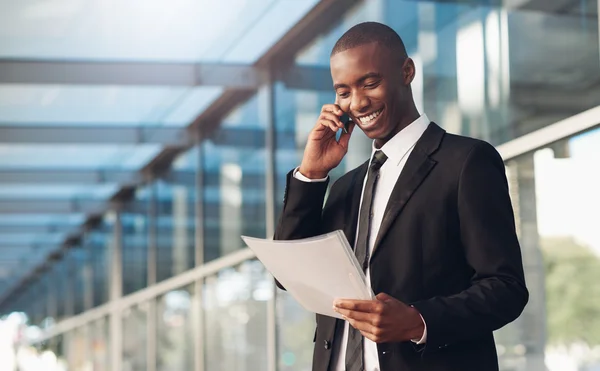 Homme utilisant le téléphone et regardant la paperasse — Photo