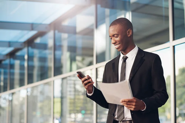 Businessman with paperwork and phone in city — Stock Photo, Image