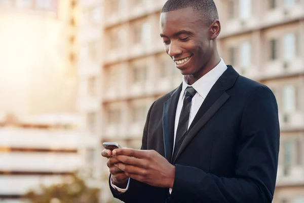 Üzletember látszó-on mozgatható telefon-ban város — Stock Fotó