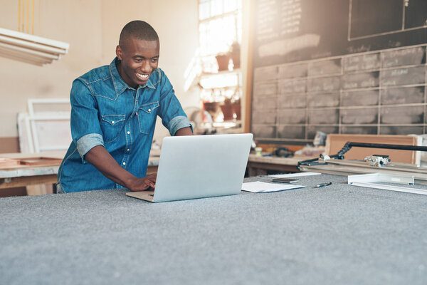 business owner using laptop in workshop