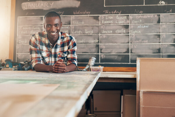 business owner leaning on work table 