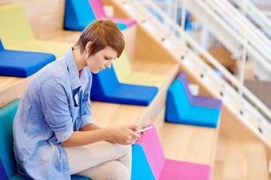 woman in coworking space with colourful cushions