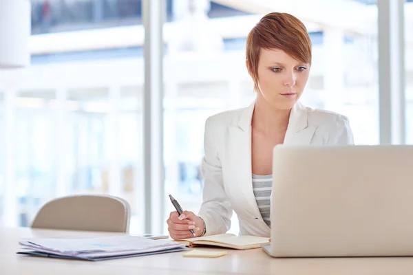 Femme d'affaires assise au bureau dans un bureau éclairé — Photo