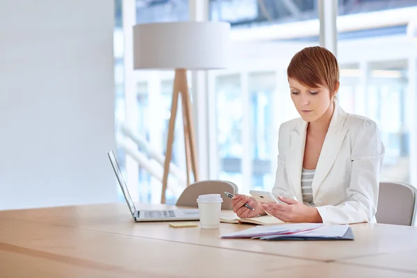 Zakenvrouw in boardroom Lees bericht op telefoon — Stockfoto