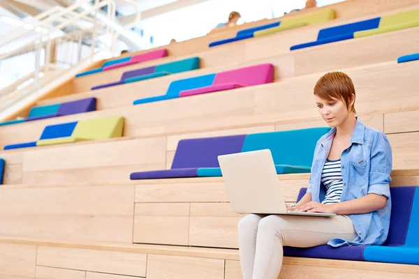 Woman working on laptop in open interior — Stockfoto