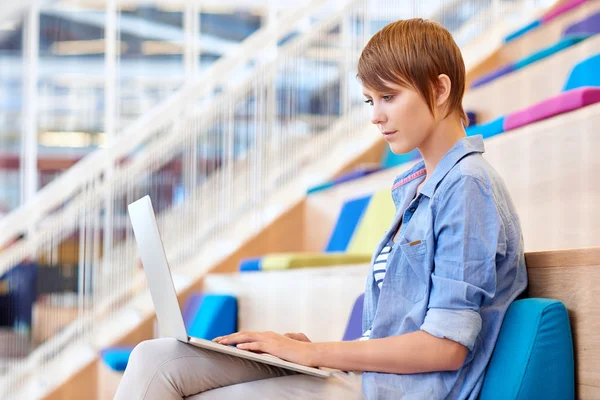 Woman working on laptop in open interior — Stock fotografie