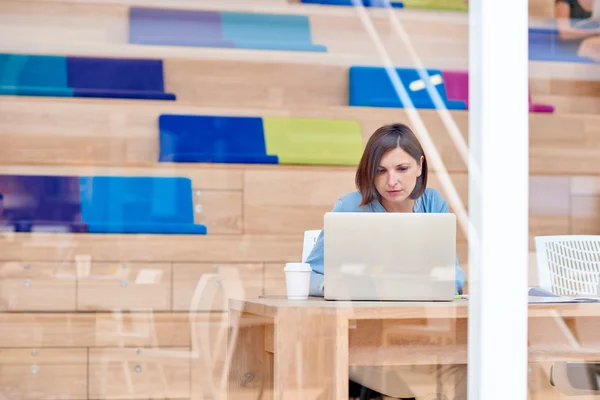 Businesswoman working on laptop in creative space — Stock Photo, Image
