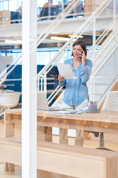 Rapporto di lettura della donna d'affari mentre parla al telefono — Foto Stock