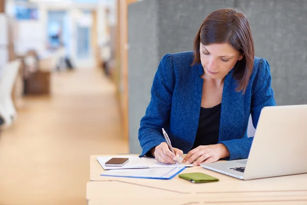 Zakenvrouw werken aan papierwerk en schrijven van notities — Stockfoto