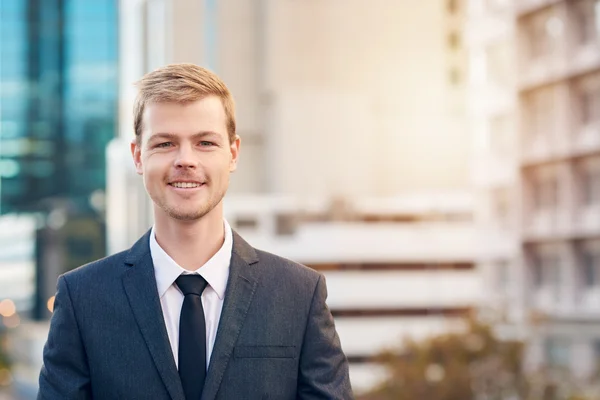 Lächelnder Geschäftsmann mit Stadt im Hintergrund — Stockfoto