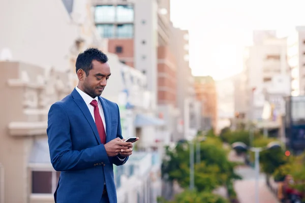 Uomo d'affari che invia SMS mentre cammina — Foto Stock